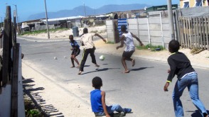 Die Jungen vor Collins Haus spielen Fußball, vier Zieglsteine dienen als Tore.